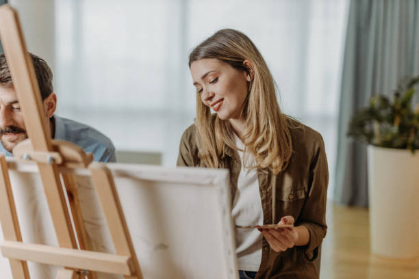 Young couple painting on canvas