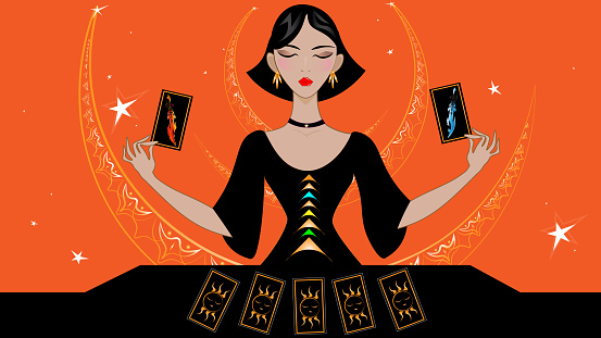 A beautiful lady future teller in an elegant black dress does a tarot reading of the future, past and present.