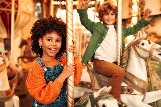 istock Kids having fun on a carnival Carousel 1472340368