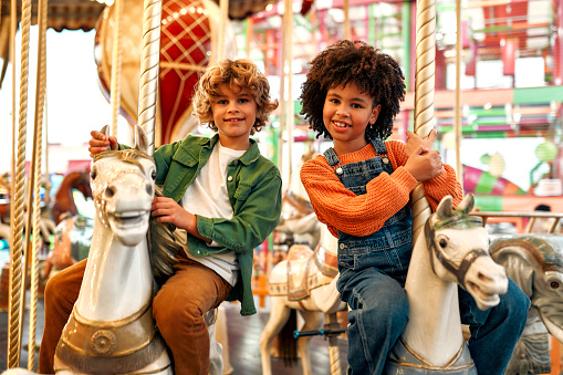 A woman and her young daughter enjoying a day out at the fair in Newcastle upon Tyne, North East England. They are on the bumper cars and the girl is screaming with her eyes closed while her mother looks excited.