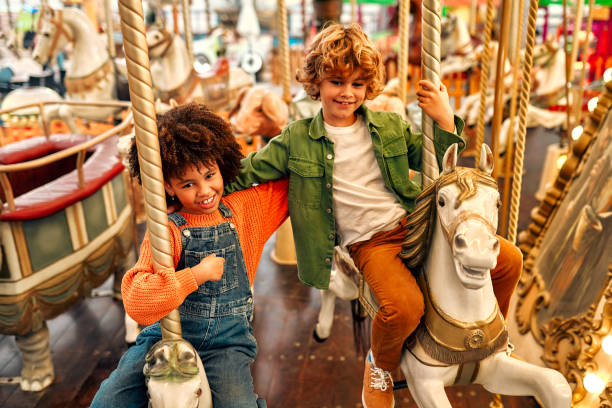 istock Kids having fun on a carnival Carousel 1472340392