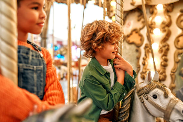 istock Kids having fun on a carnival Carousel 1472340409