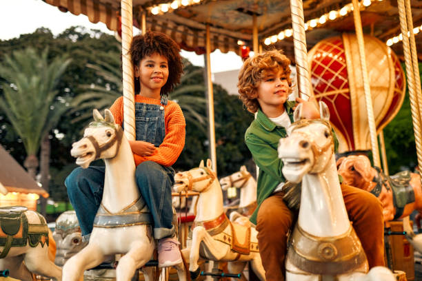 istock Kids having fun on a carnival Carousel 1472340411