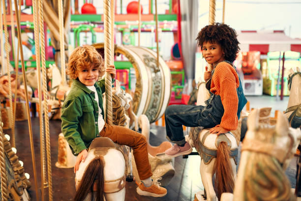 istock Kids having fun on a carnival Carousel 1472340415