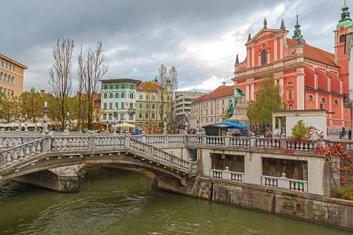 Ljubljana, Slovenia - November 4, 2019: Triple Bridge Over Ljubljanica River at Capital City Centre Cloudy Autumn Day.