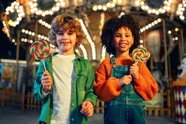 los niños se divierten en un carnaval de carrusel - carousel merry go round child african descent fotografías e imágenes de stock