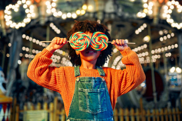 los niños se divierten en un carnaval de carrusel - carousel merry go round child african descent fotograf�ías e imágenes de stock
