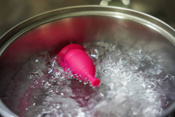 menstrual cup boiling in water. feminine intimate hygiene menstrual cup boiling in water. feminine intimate hygiene boiling menstrual cup stock pictures, royalty-free photos & images