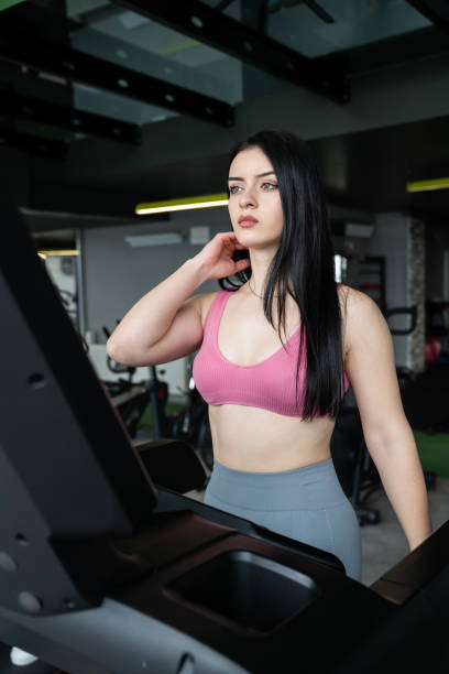 istock Young sportswoman exercise by run on treadmill in gym. 1472348327