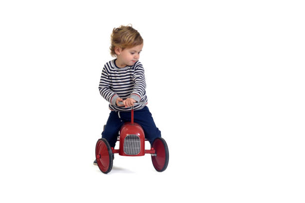 Girl and boy pulling their brother sitting in a handcart