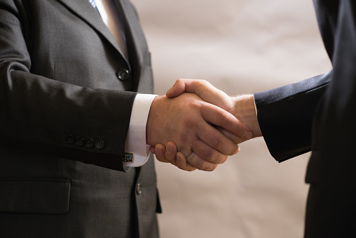 Business handshake of two businessmen in suits, negotiate and make a deal.