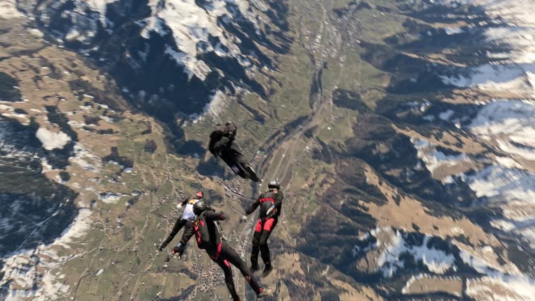 Freefall jumpers soar above Swiss mountain landscape