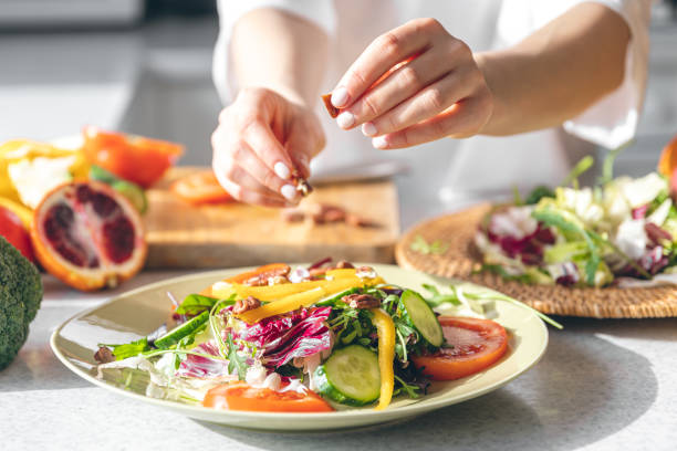 istock A woman makes a fresh vegetable salad, close-up. 1472352032