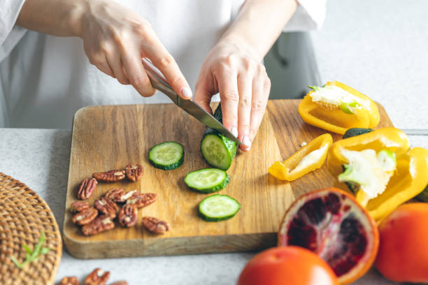 istock A woman cuts vegetables for a salad, close-up. 1472352080