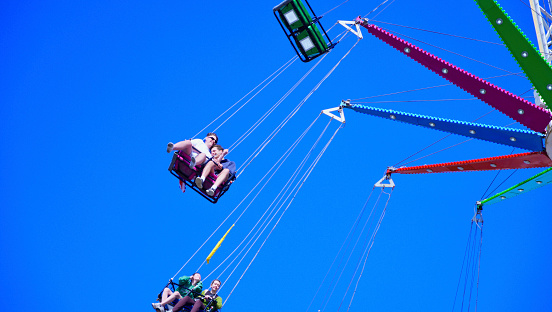 Happy girls having fun in an amusement park riding on a fun ride and screaming - lifestyle concepts