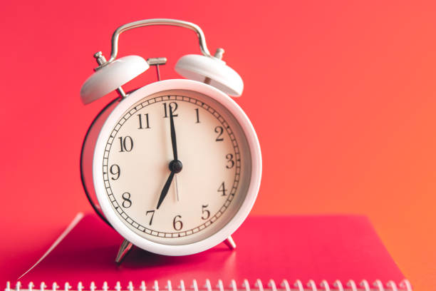 istock White alarm clock and notebook on Viva Magenta background. 1472352791