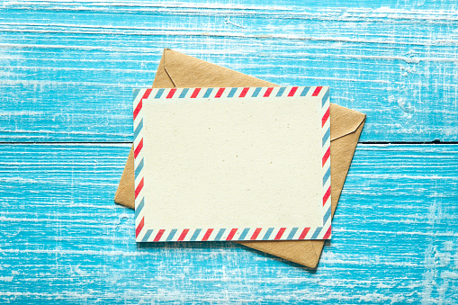 Vintage envelope and postcard for text on a blue wooden background, top view, copy space.