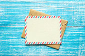 Envelope and postcard for text on a blue wooden background, top view.