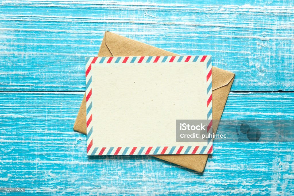 Envelope and postcard for text on a blue wooden background, top view. Vintage envelope and postcard for text on a blue wooden background, top view, copy space. Envelope Stock Photo