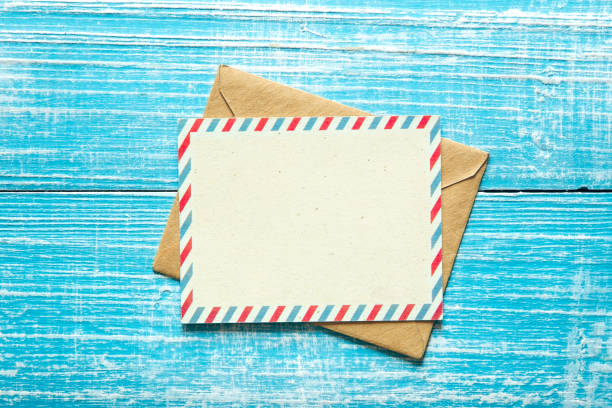 Envelope and postcard for text on a blue wooden background, top view. stock photo