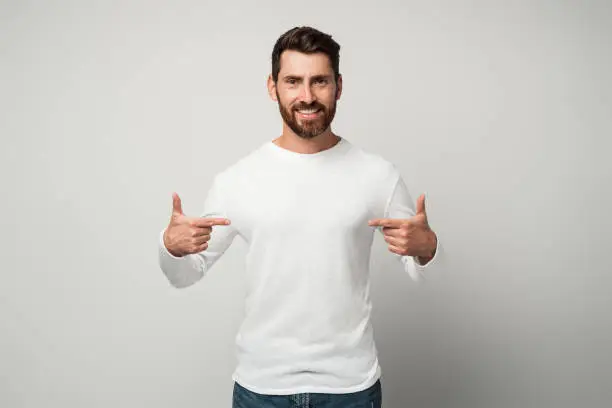 Photo of Self-confident narcissistic man smiling satisfied and pointing himself