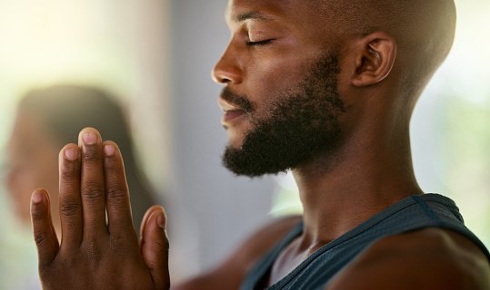 Meditation, black man and namaste in yoga gym for mental health, zen exercise and pilates. Face of african guy meditate for wellness, hope and calm fitness workout, chakra mindset and training class