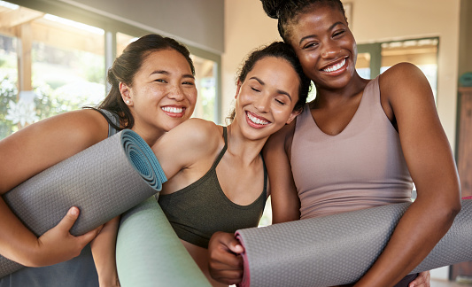 Portrait, yoga and women friends in gym after stretching for health, wellness and flexibility. Zen, mat and group of happy girls ready to start meditation, pilates or workout, exercise or training.