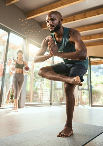 Black man, class and yoga training for pose in morning, wellness or happiness with students. Personal trainer, women and studio for fitness, exercise or health with balance, mindset and praying hands