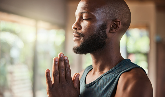 Meditation, black man and namaste hands in home of mental health, zen exercise and pilates. Face, yoga and african guy meditate for wellness, hope and calm fitness workout, chakra mindset or training