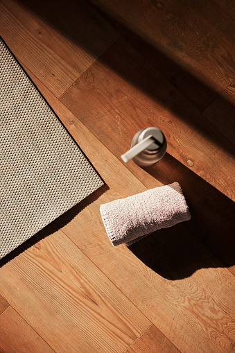 Flatlay, fitness and equipment for training on the floor of a gym for sports, workout and yoga. Water, towel and above of a mat in an empty room for exercise, pilates and start of cardio for health