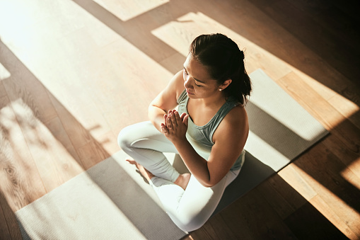 Meditation, yoga and top view of woman with prayer hands in home for health and wellness. Meditate namaste, zen chakra and female yogi workout, exercise or training for pilates, mindfulness and peace