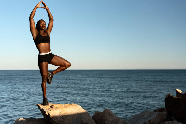 istock Woman standing at the one leg with closed eyes while practicing yoga 1472358784