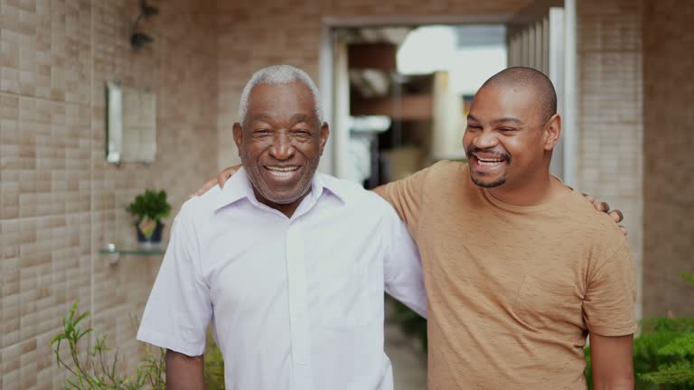 Father and son embracing and talking in the backyard at home