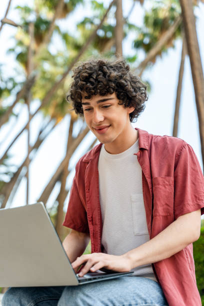 istock Cheerful man blogger chatting in social networks or browsing web page on laptop computer 1472362471