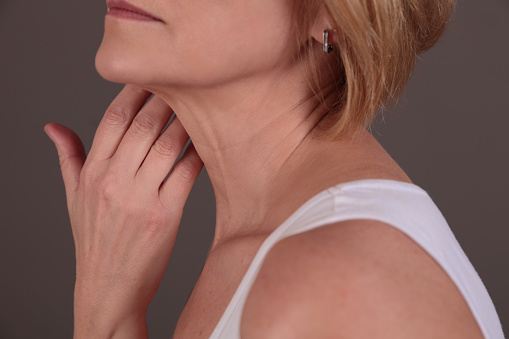 Female neck and shoulders close up. Woman thyroid gland control.