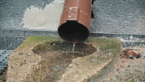 istock Rain Water Dripping from Metal Gutter on Sidewalk Pavement 1472364105
