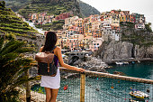 Woman enjoying the view on beautiful town in Cinque Terre coast, Italy