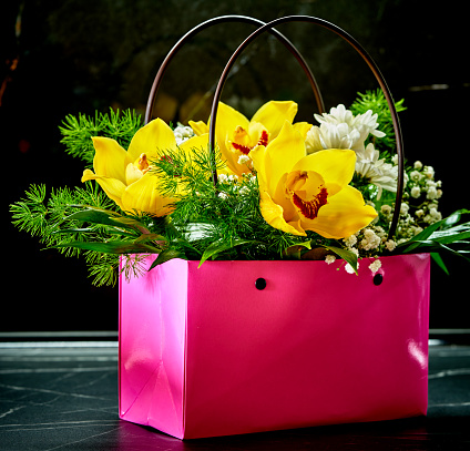 a bouquet of flowers is in a pink basket