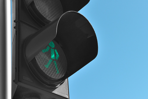 Traffic light with green signal against blue sky, closeup