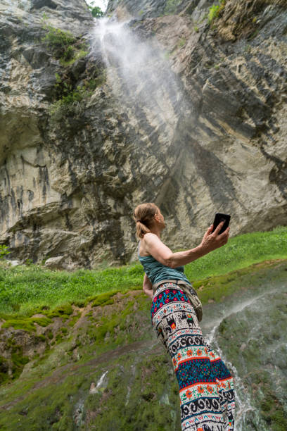 Young woman relaxes on rocky shoreline