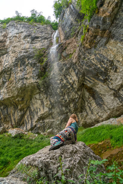 istock Mature women at the waterfall falling on rocks 1472379165