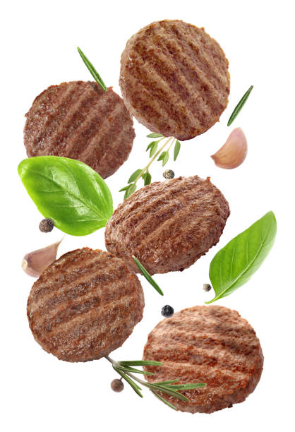 istock Tasty grilled hamburger patties and spices falling on white background 1472379322