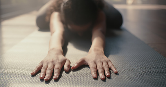 Yoga, balasana pose and woman hands for wellness training, holistic fitness and exercise in studio. Pilates, workout and stretching person on floor with meditation, spiritual balance in mental health