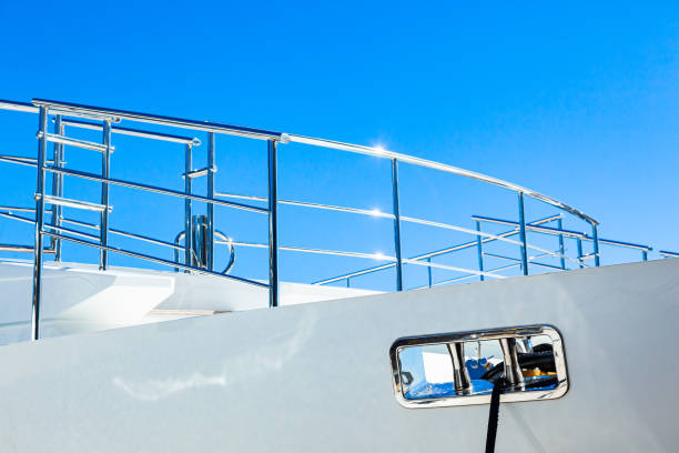 The bow of a luxury white yacht with handrails and a stainless steel hawse, viewed from the side against the sky. The bow of a luxury white yacht with handrails and a stainless steel hawse, viewed from the side against the sky. mooring line stock pictures, royalty-free photos & images
