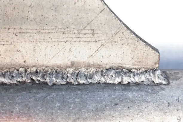 Photo of Welding seam connecting aluminum parts. Aluminum welding.