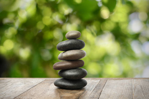istock Stacked stones on wooden table against blurred background. Zen concept 1472381450