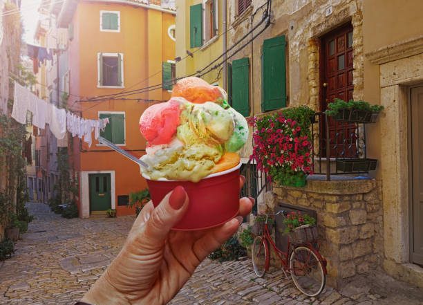 Woman hand hold   sweet ice - cream cone with different flavors  held in hand  in  Rovinj stock photo