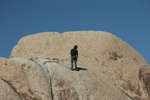 On February 20, 2023 visitors to Joshua tree national park are enjoying the sunny day this person is climbing the rocks using safety equipment
