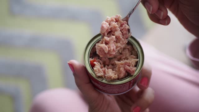 women holding a canned tuna