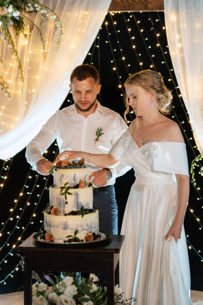 istock newlyweds happily cut and taste the wedding cake 1472387440